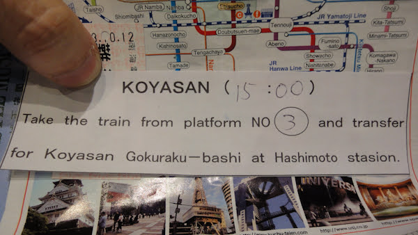 a paper slip reads: Koyasan (15:00).  Take the train from platform No. 3 and transfer for Koyasan Gokuraku-bashi at Hashimoto stasion (sic). The time and platform number have been written in.
